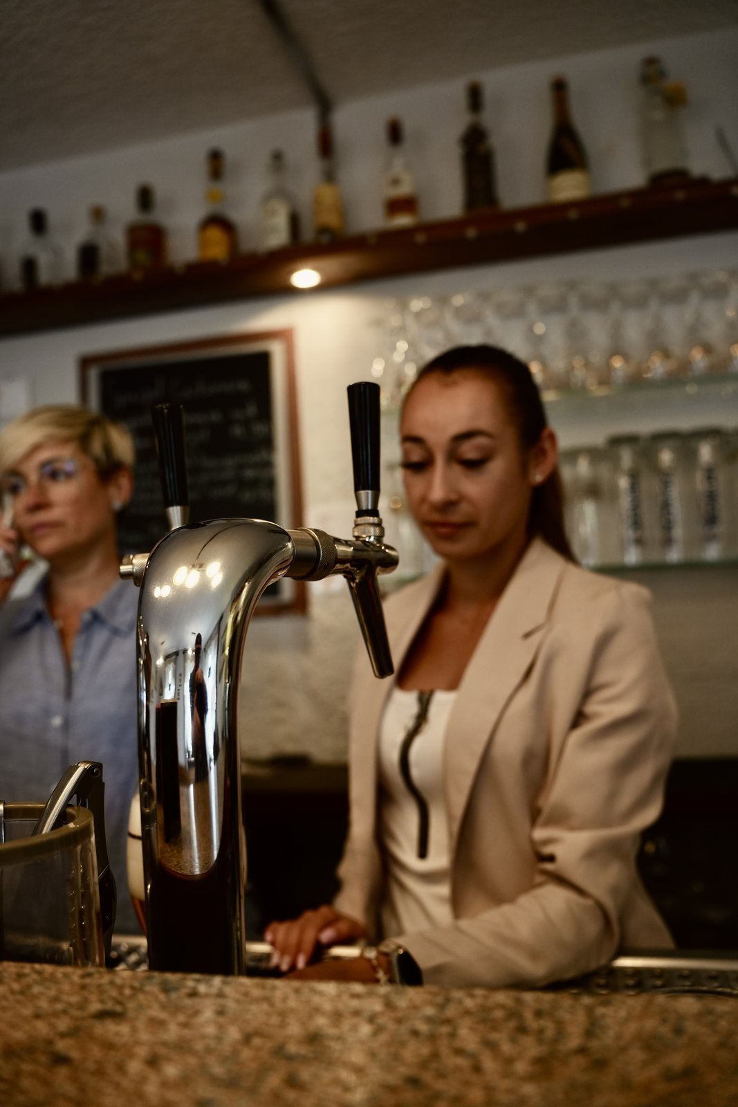 Mitarbeiterin zapft frisches Bier am Zapfhahn
